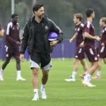 Vítor Bruno met een bal op een voetbalveld in zwarte trainingskleding.