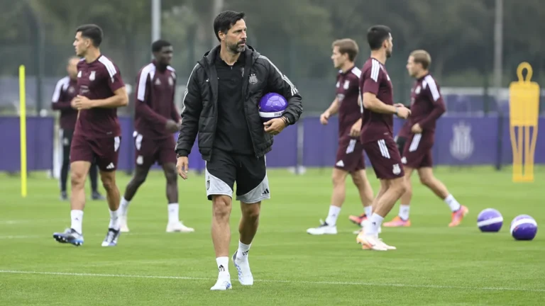 Vítor Bruno met een bal op een voetbalveld in zwarte trainingskleding.