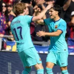 Twee spelers van FC Barcelona vieren samen een moment tijdens een wedstrijd.
