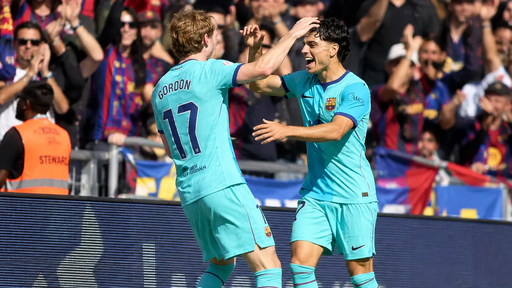 Twee spelers van FC Barcelona vieren samen een moment tijdens een wedstrijd.