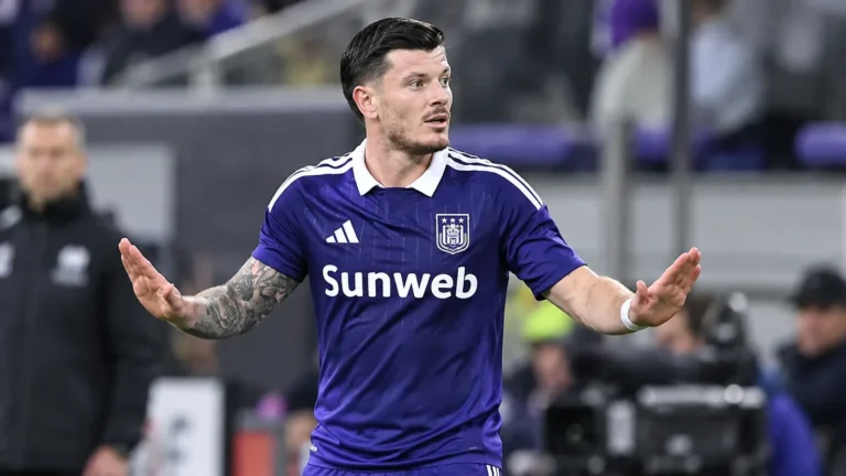 Giulian Biancone van Anderlecht staat met gespreide armen op het veld.