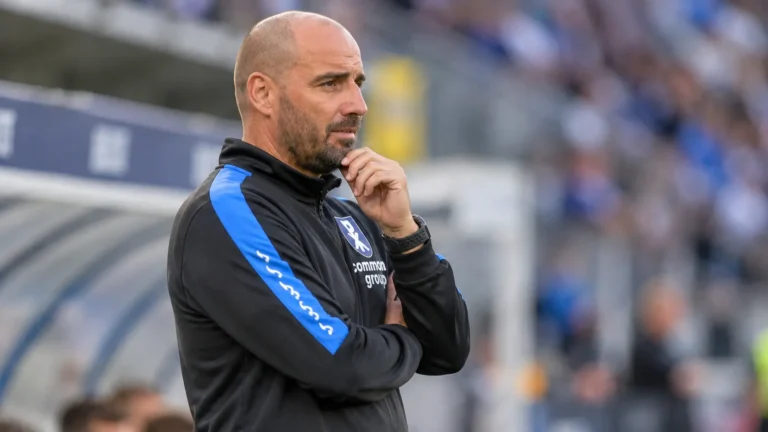 Stijn Stijnen in Patro Eisden-kleding aan de zijlijn van een stadion.
