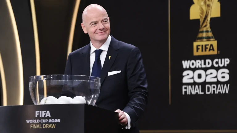 Een FIFA-official in donker pak voor het decor van een WK-loting.