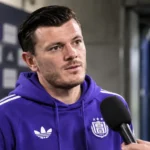 Giulian Biancone in paarse Anderlecht-kleding tijdens een interview aan de rand van het veld.