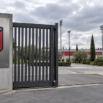 De lege ingang van een trainingscomplex van Atlético Madrid met een fysiek geïntegreerd clubembleem.