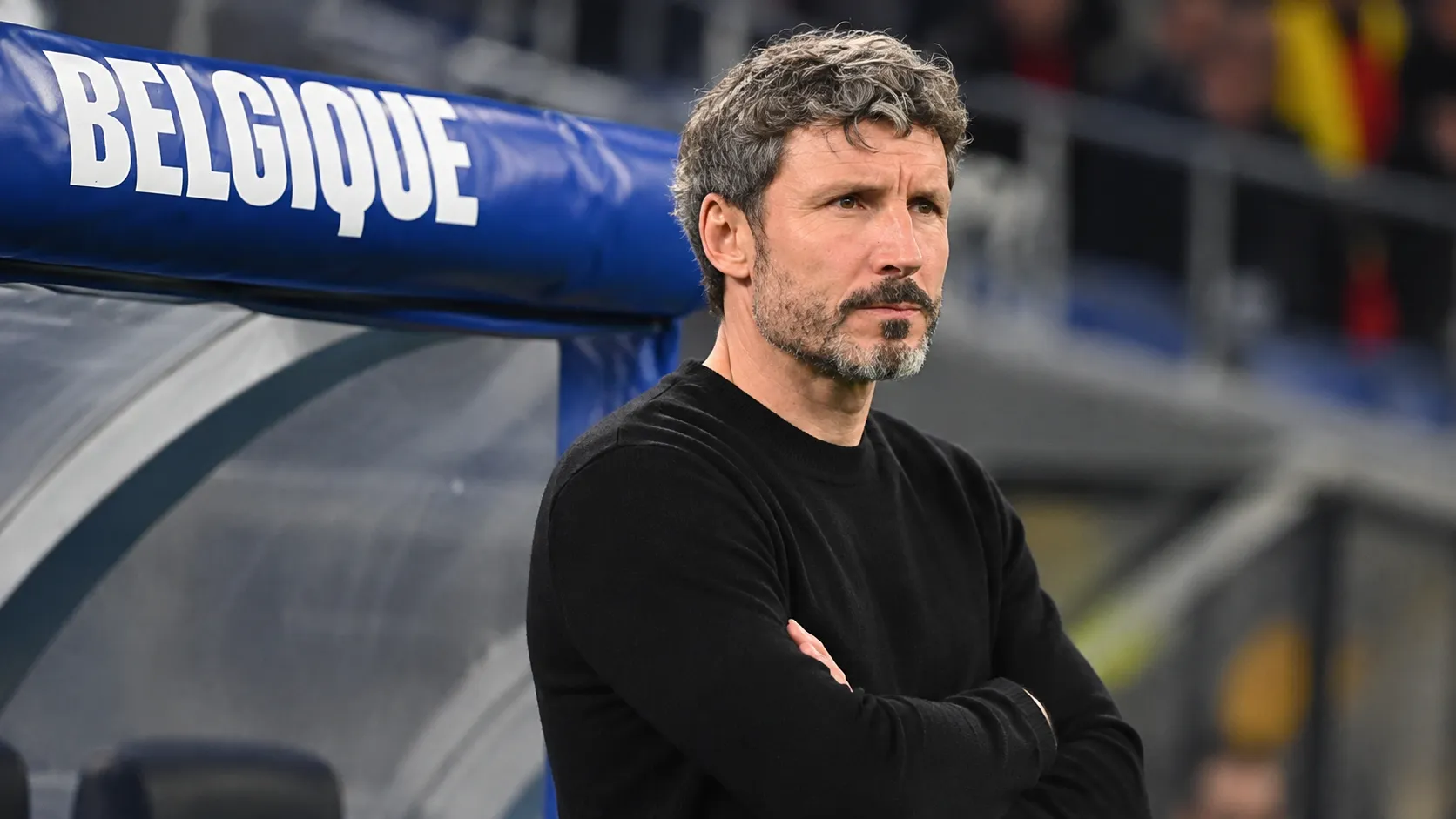 Mark van Bommel staat geconcentreerd in de technische zone bij een Belgische dug-out.