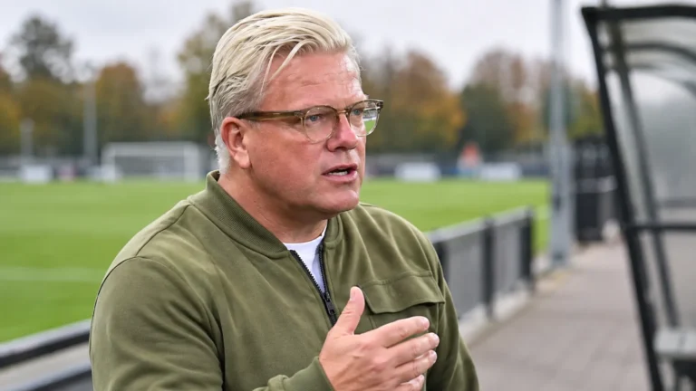 Lars Friis spreekt naast een voetbalveld in een rustige clubomgeving.