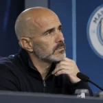 Enzo Maresca tijdens een persmoment met een Manchester City-embleem op de achterwand.