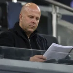 Arne Slot in een UEFA-observatieruimte op de tribune met wedstrijdnotities.