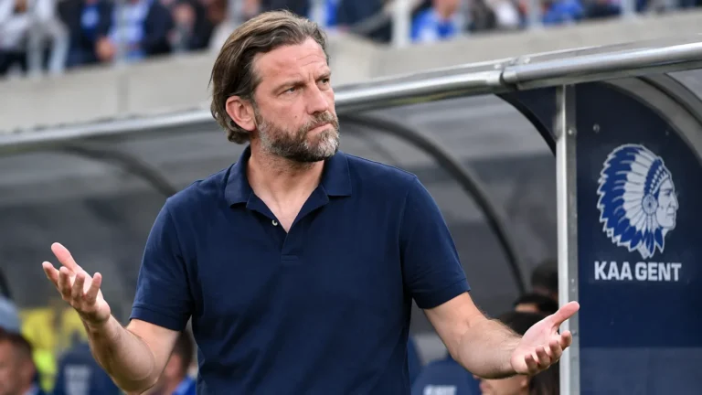 Rik De Mil in een donkere polo naast de dug-out van KAA Gent.