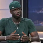 Cheikhou Kouyaté tijdens een televisie-interview in een neutrale studio.