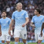 Erling Haaland staat met ploegmaats van Manchester City op het veld.
