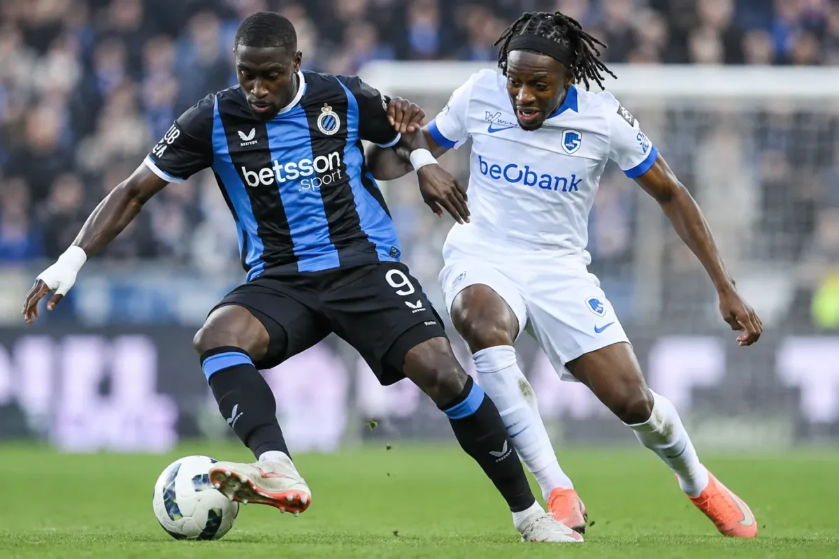 Twee voetballers van Club Brugge en KRC Genk vechten om balbezit in een duel.