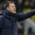 Michael Beale geeft aanwijzingen vanaf de zijlijn in een donker gewatteerd coachjack.