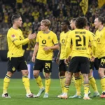 Een groep Borussia Dortmund-spelers in gele wedstrijdtenues op het veld.
