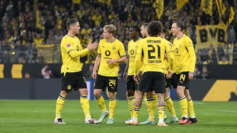 Een groep Borussia Dortmund-spelers in gele wedstrijdtenues op het veld.