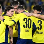 Een groep spelers van Union vormt samen een hechte kring op het veld.