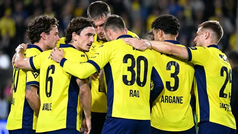 Een groep spelers van Union vormt samen een hechte kring op het veld.