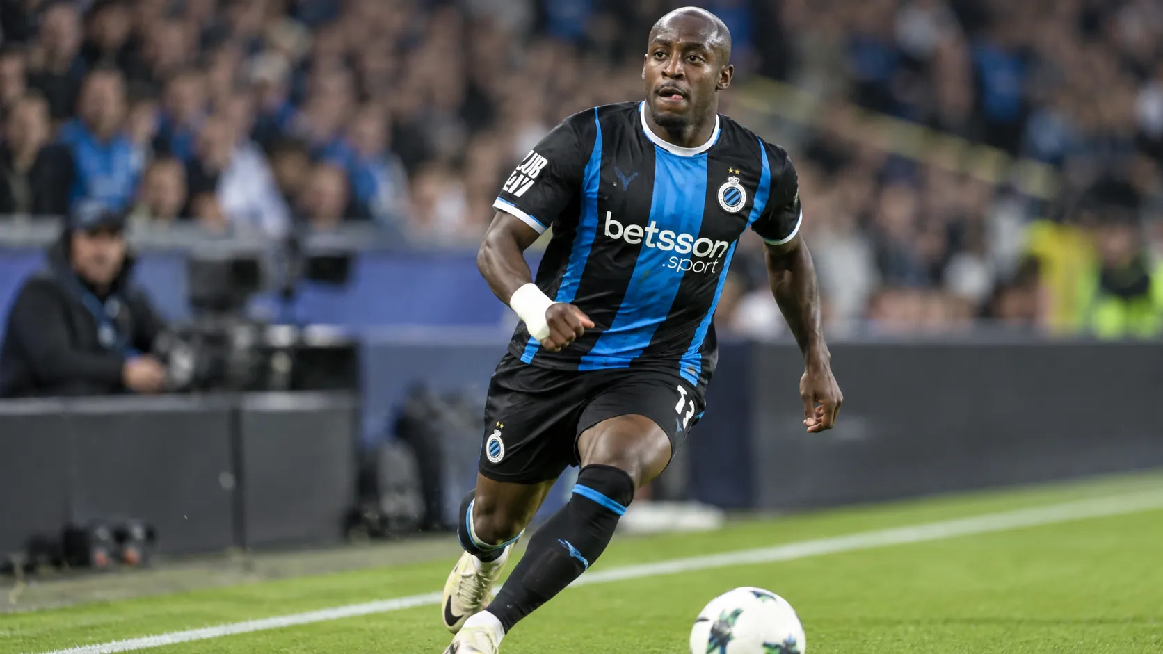 Carlos Forbs van Club Brugge in actie met de bal aan de zijlijn.