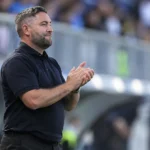 Lee Johnson staat na de wedstrijd aan de zijlijn in een donker poloshirt.