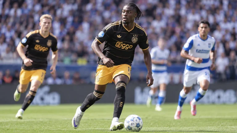 Jorthy Mokio in het zwarte en gouden wedstrijdtenue van Ajax tijdens een wedstrijd.