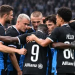 Een groep spelers van Club Brugge verzamelt in een hechte huddle op het veld.