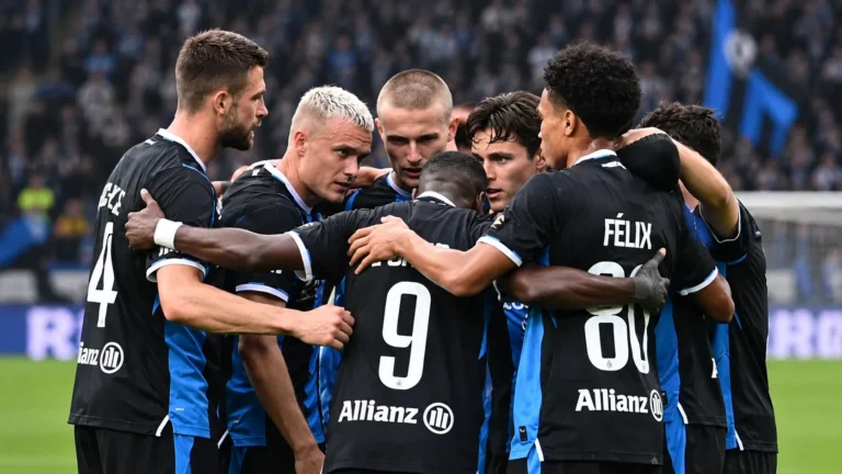 Een groep spelers van Club Brugge verzamelt in een hechte huddle op het veld.