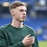 Cole Palmer in een groen trainingsbovenstuk aan de rand van een voetbalveld.