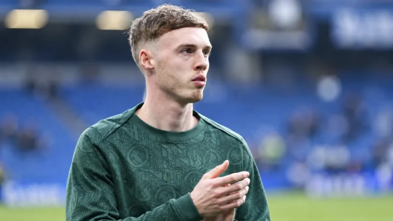 Cole Palmer in een groen trainingsbovenstuk aan de rand van een voetbalveld.