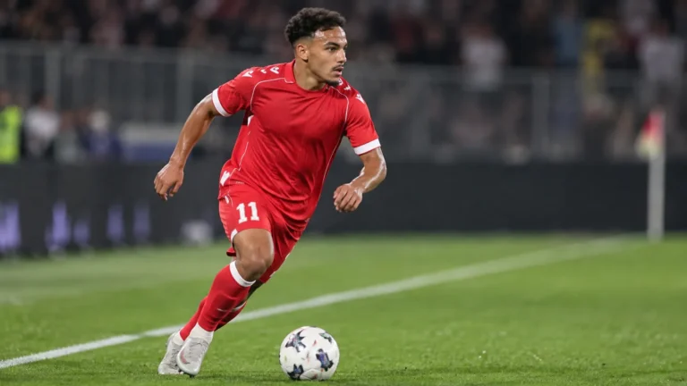 Adnane Abid in een rood shirt tijdens een actie op de linkerflank.