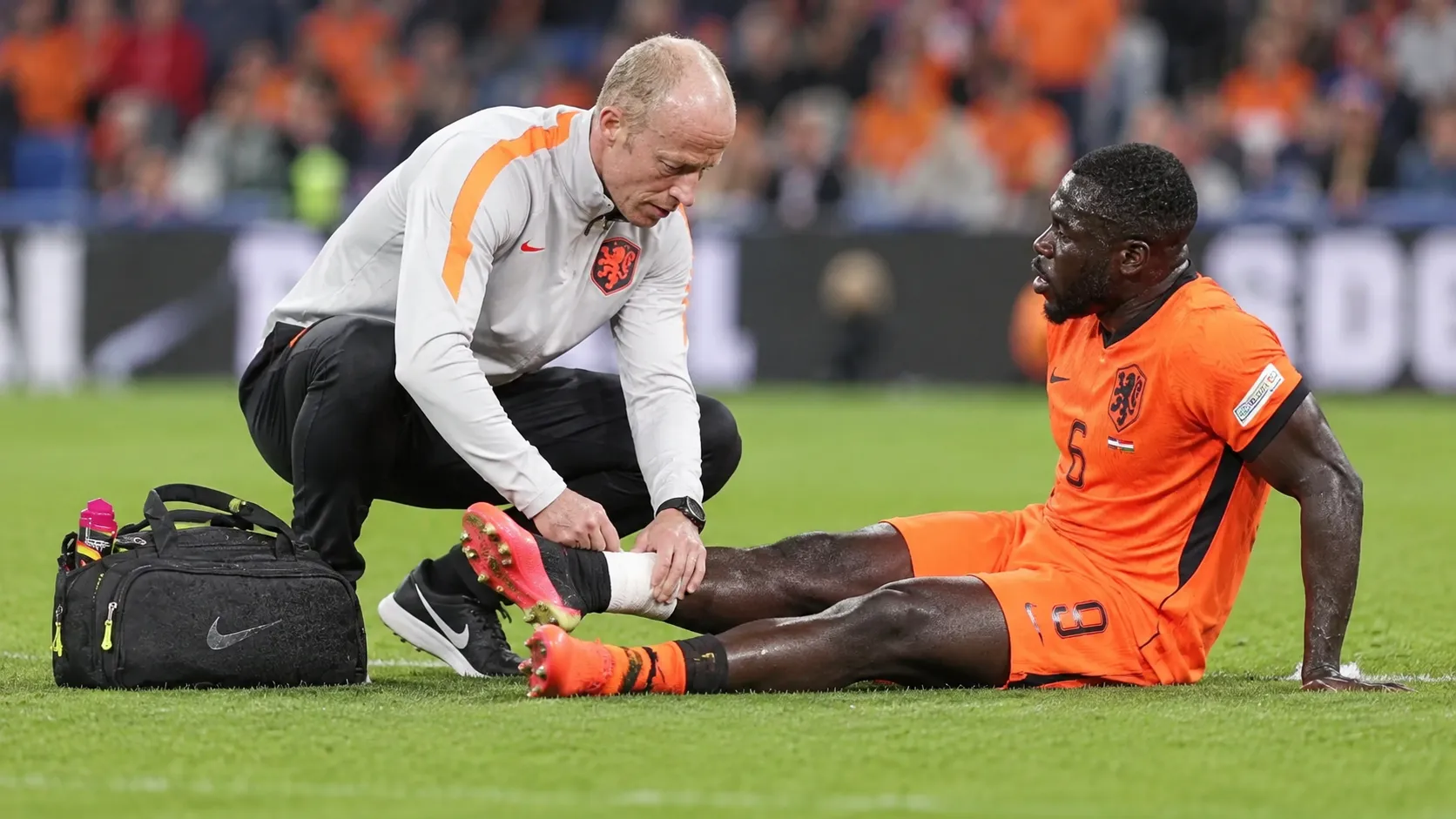 Een Nederlandse speler krijgt op het veld verzorging van een lid van de medische staf.