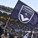 Supporters van Girondins de Bordeaux met een grote paarse clubvlag in het stadion.