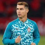 Cristiano Ronaldo in een Portugese opwarmtrui aan de rand van het veld.