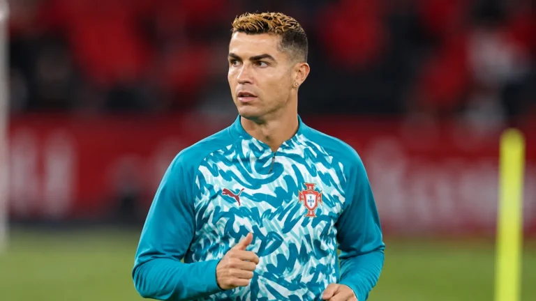 Cristiano Ronaldo in een Portugese opwarmtrui aan de rand van het veld.