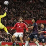 Een doelman en meerdere spelers in actie voor doel tijdens een wedstrijd op Old Trafford.