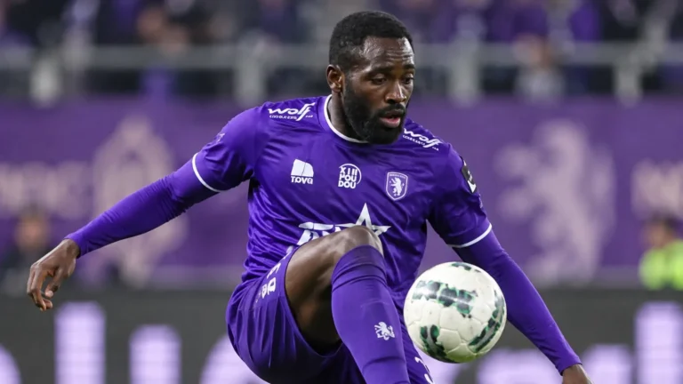 Een Beerschot-speler in paars controleert de bal tijdens een wedstrijd.