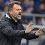 Ivan Leko geeft aanwijzingen langs de zijlijn in een zwart coachjack.