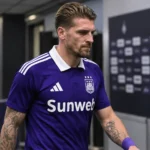 Adriano Bertaccini loopt na de wedstrijd door de mixed zone in zijn paarse wedstrijdshirt.