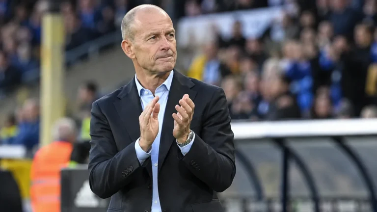 Jess Thorup kijkt geconcentreerd langs de zijlijn van een stadion.