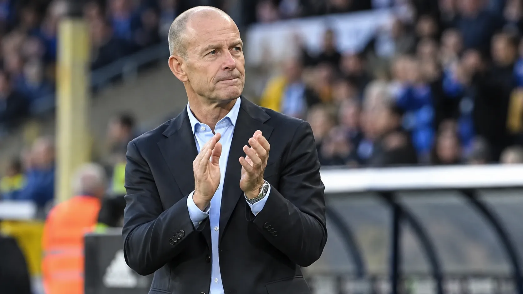 Jess Thorup kijkt geconcentreerd langs de zijlijn van een stadion.
