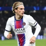 Mika Godts van PSG tijdens een wedstrijd onder stadionverlichting.