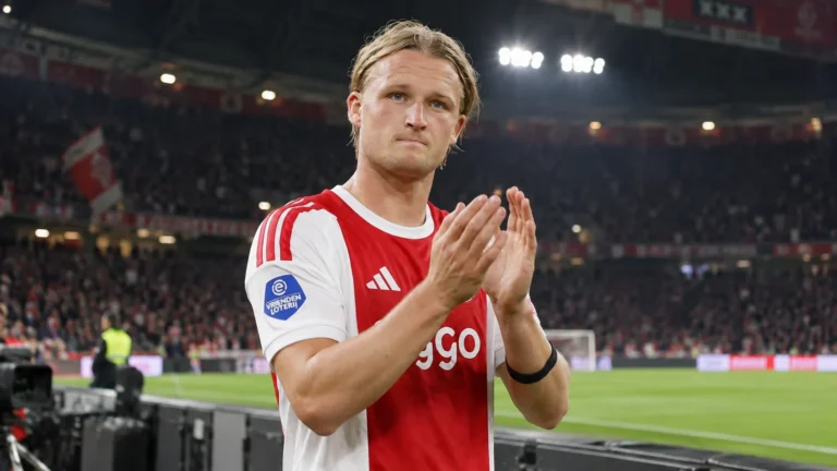 Kasper Dolberg in het rood-witte shirt van Ajax applaudisseert langs het veld.