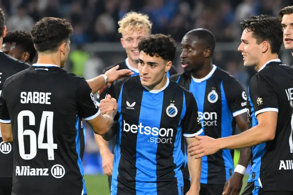Een groep spelers van Club Brugge feliciteert elkaar na de wedstrijd op het veld.