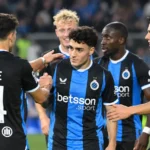 Een groep spelers van Club Brugge feliciteert elkaar na de wedstrijd op het veld.