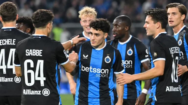 Een groep spelers van Club Brugge feliciteert elkaar na de wedstrijd op het veld.