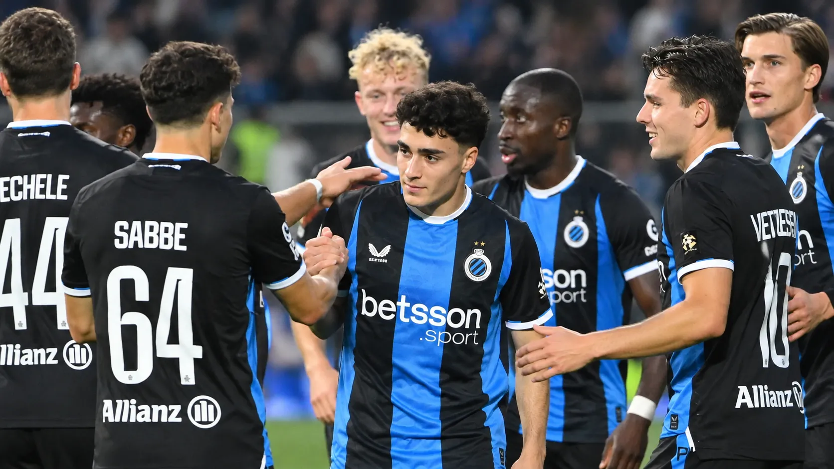 Een groep spelers van Club Brugge feliciteert elkaar na de wedstrijd op het veld.