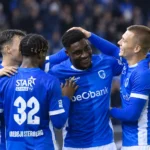 Een groep spelers van KRC Genk viert samen op het veld na de thuiszege.