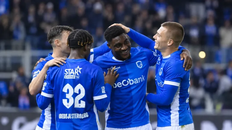 Een groep spelers van KRC Genk viert samen op het veld na de thuiszege.