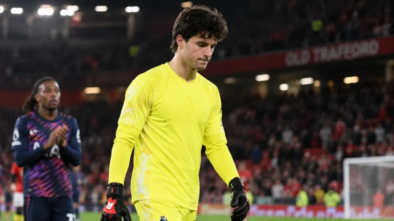 Senne Lammens in geel doelmanstenue op het veld van Old Trafford na het eindsignaal.