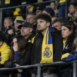 Supporters van Union met geel-blauwe sjaals op de tribune na de thuiswedstrijd tegen OHL.